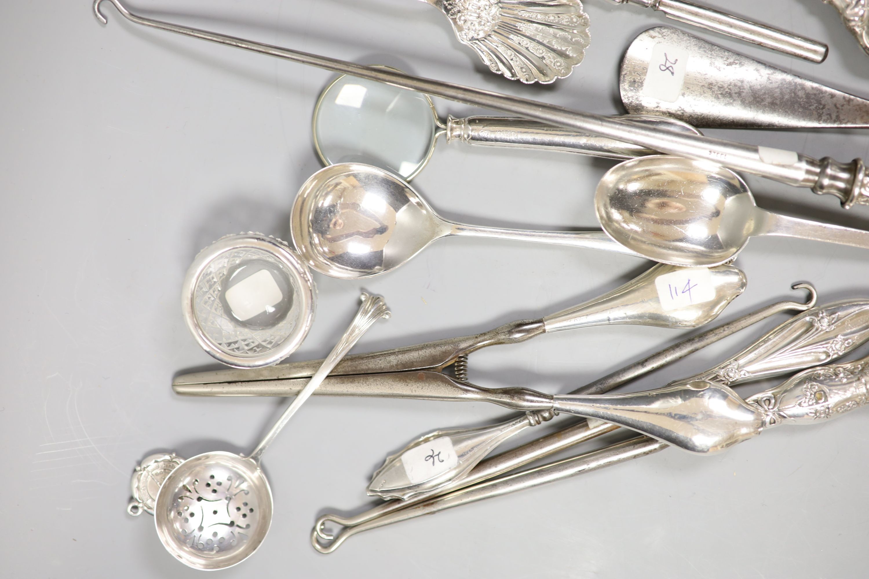 Assorted button hooks and other small silver including spoons, magnifying glass, glove stretchers, shooting related medallion and enamelled stamp case, etc.